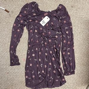 It purple with tan and red flowers and has long sleeves